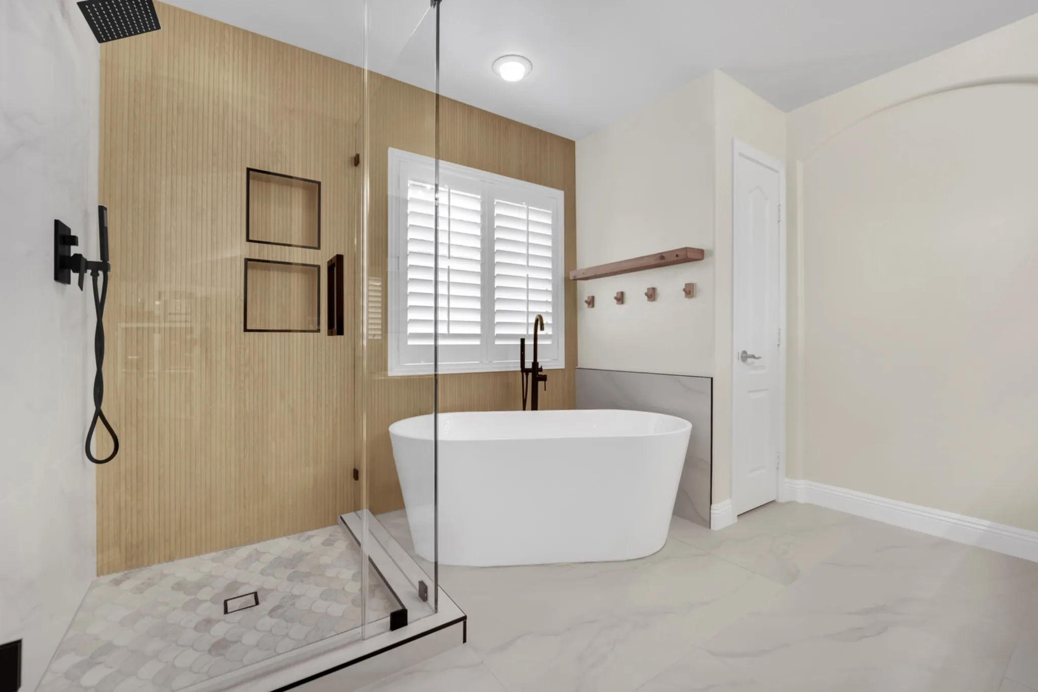 Centennial Heights primary bathroom remodel with a freestanding tub, custom glass shower, and wood-look feature wall