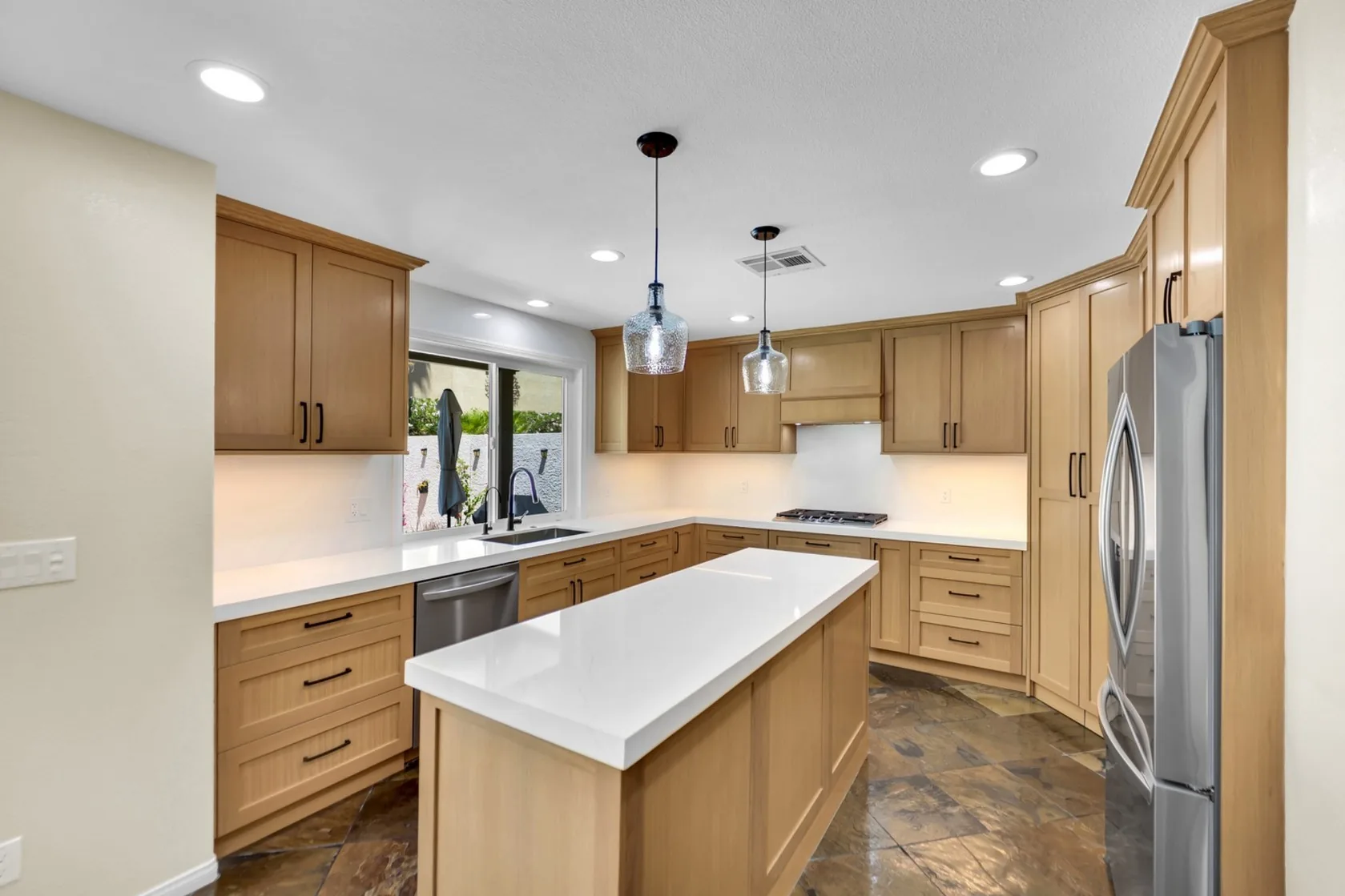 Rift white oak custom kitchen with Cambria white quartz island and retained stone tile flooring